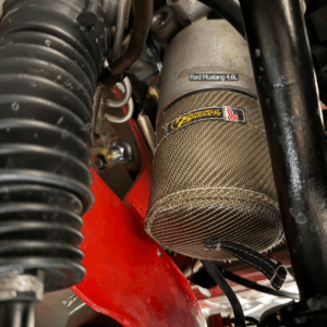 Oil filter heat shield installed on a 2004 Mustang GT engine to protect the oil filter from radiant exhaust heat.