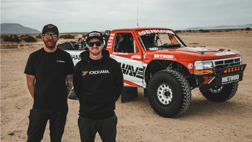 Nick and Chris Isenhouer standing beside the Isenhouer Racing T2 off-road truck in a desert setting