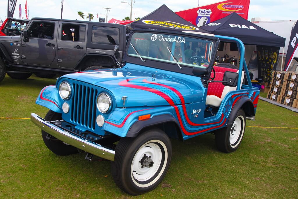 Bright Blue Jeep with Red Swirls Sits at Car Show