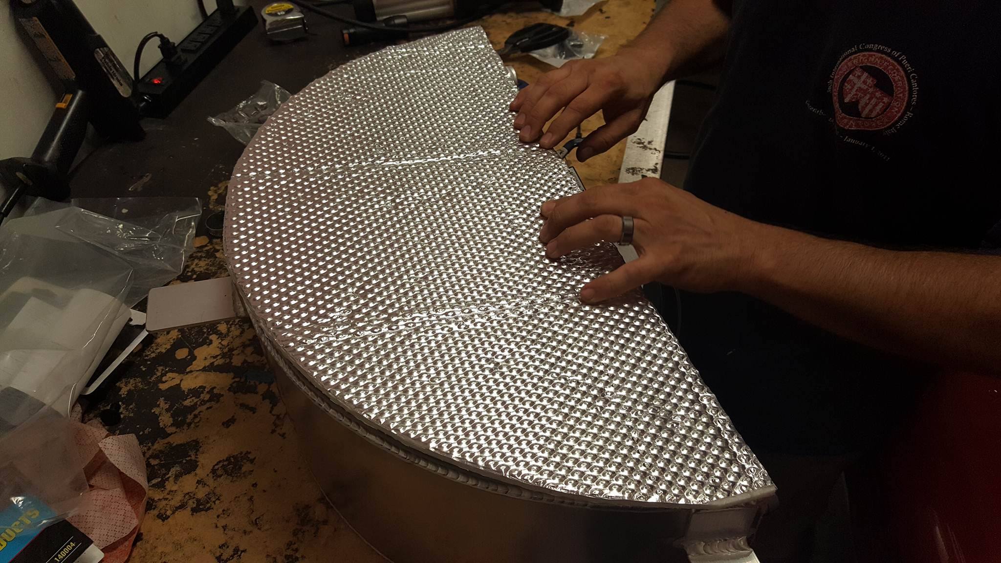 A Heatshield Product’s team member installs a heat shield to a custom intercooler.