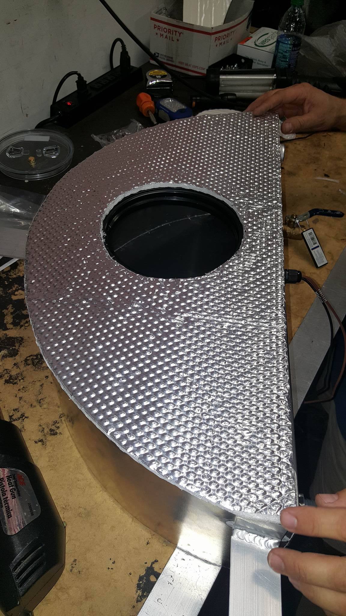 A mechanic creates a custom intercooler heat shield.
