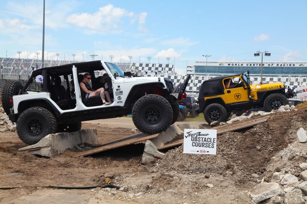 White and Yellow Jeeps Drive Over Rocky Obstacle Course