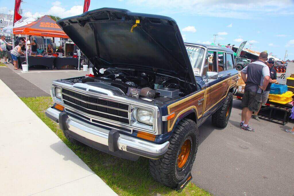 Blue and Wood Paneled Car with Hood Popped at Car Show