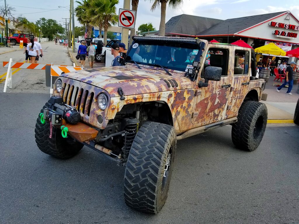 Jeep with Faux Rusted Paint Job Parked at Car Show 