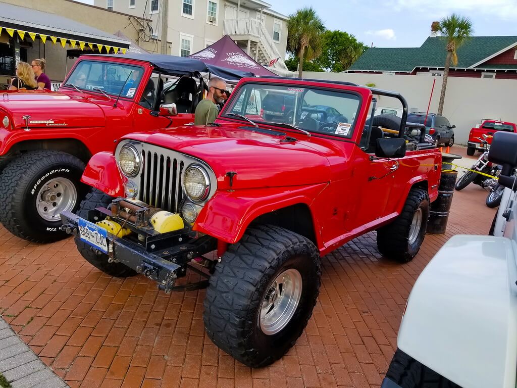 Two Red Jeeps Parked Side by Side at a Car Show