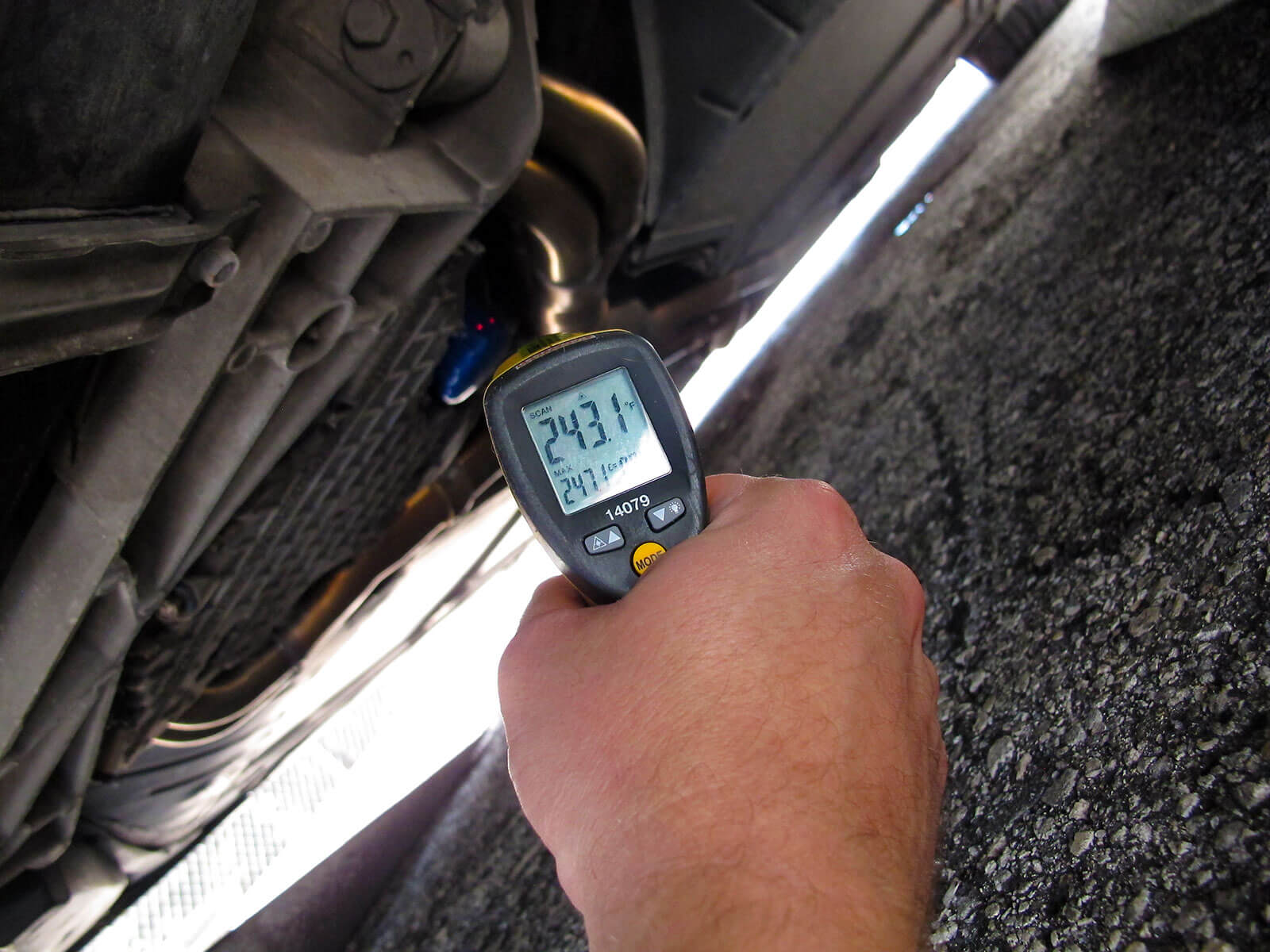 Man Takes Temperature of Car Under Carriage