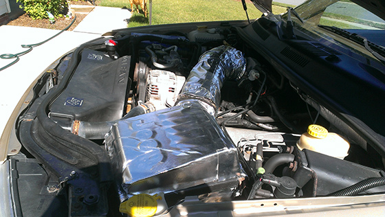DIY cold air intake with Heatshield Products installed on Jeep Cherokee engine.