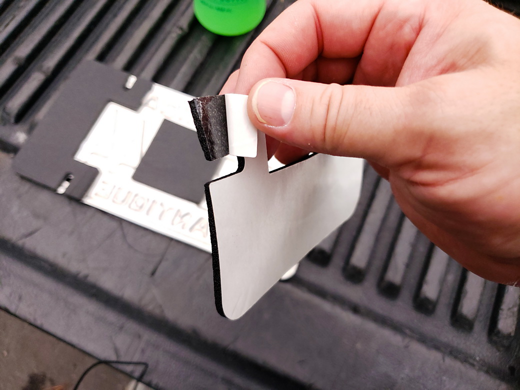 Applying the Heatshield Products LP Shield pieces to the back of the license plate