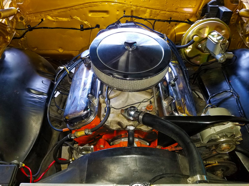Fuel line protective sleeve being installed in a car engine.