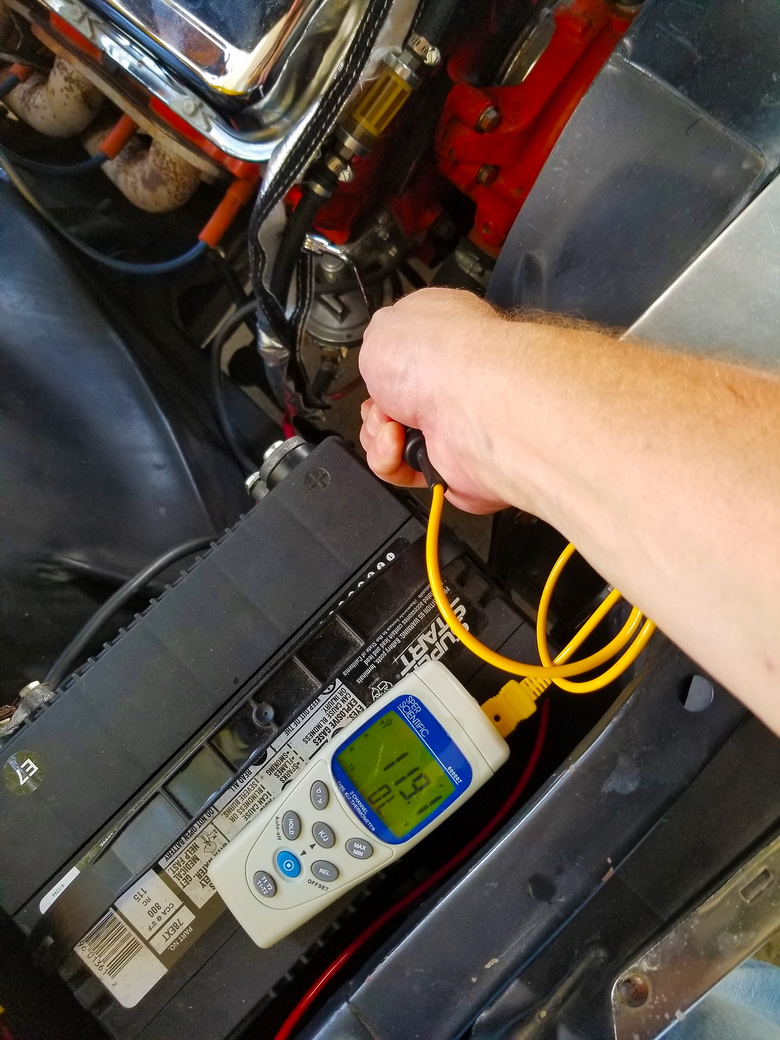 A digital thermometer reads the heat from an engine without fuel line protective sleeves.

