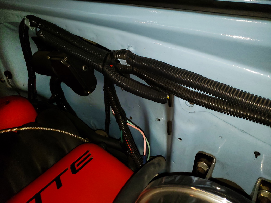 Firewall mounted wiring harness with cheap plastic wire loom material installed