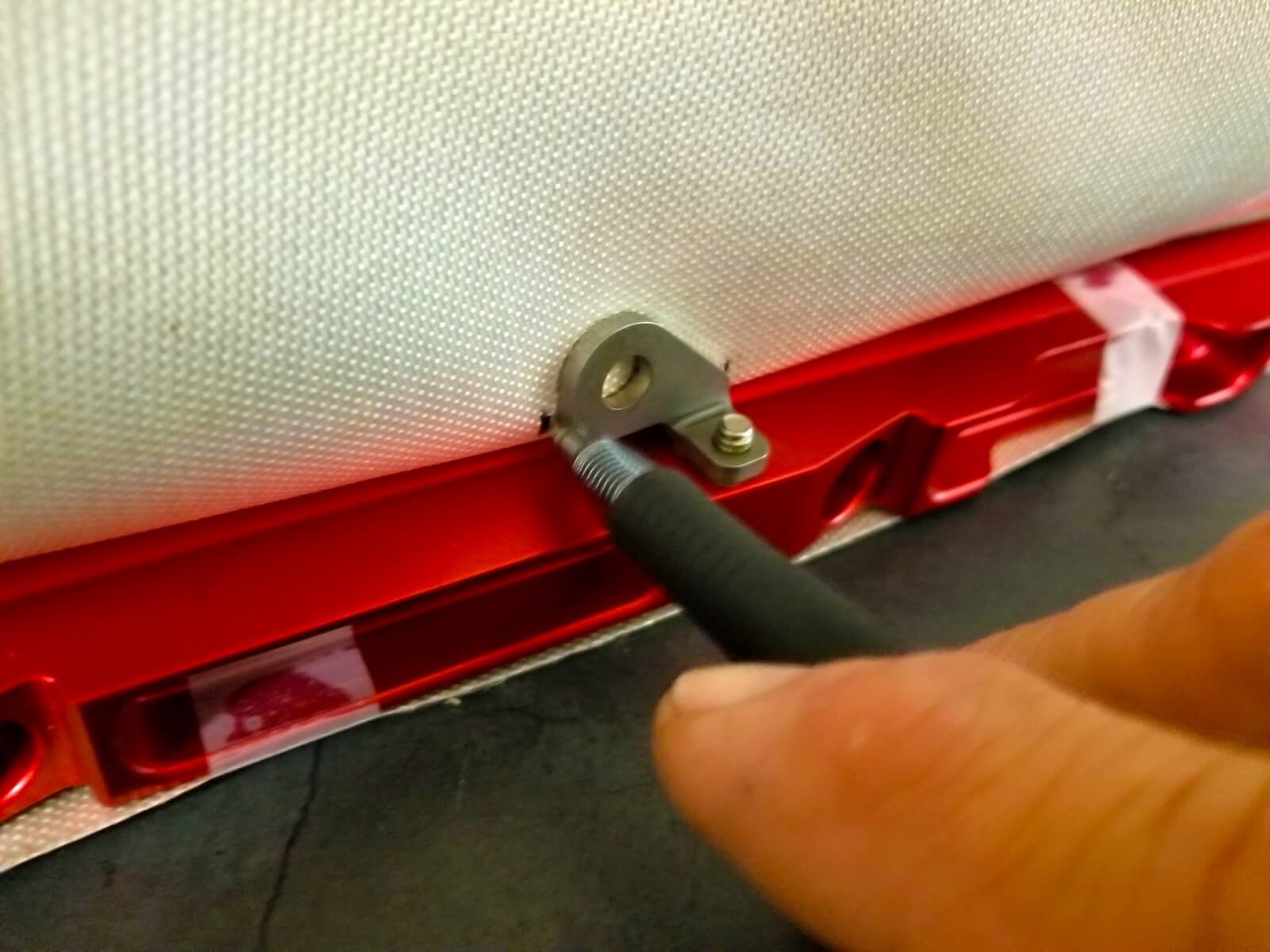 A man marks where to cut a slit in fuel line insulation.