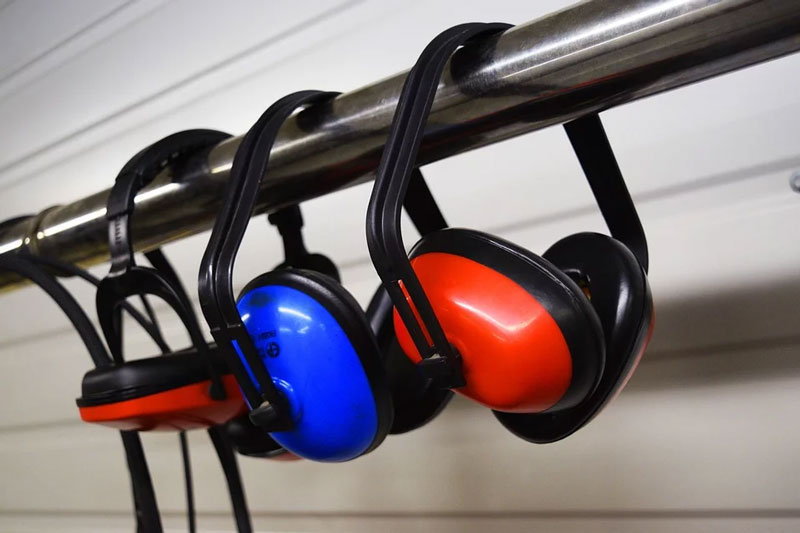 Industrial insulation supplies colored earmuffs hanging on a rail