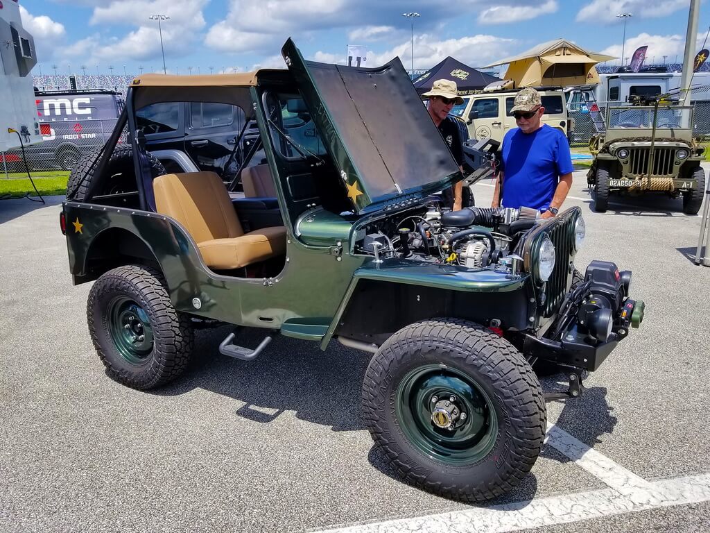 Green Vintage Army Jeep With Hood Open at Car Show 