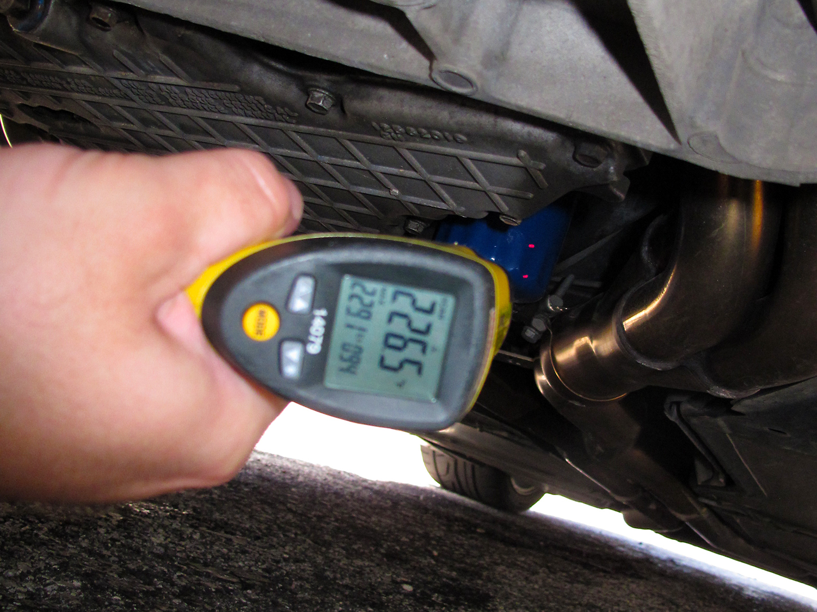 Man Takes Temperature of Car Under Carriage