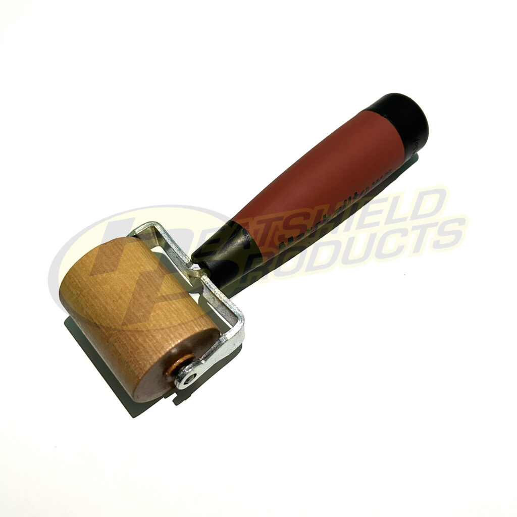 Wooden installation roller for applying automotive heat shields and insulation materials