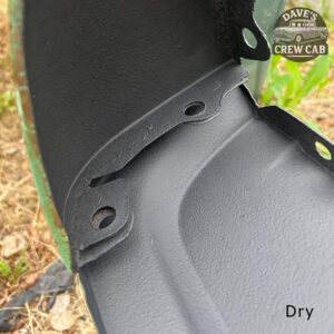Close-up of a black, matte-finished metal car part with three bolt holes, shown outdoors on grass. The image is labeled Dry in the bottom right corner and has a Daves Crew Cab logo in the upper right corner.