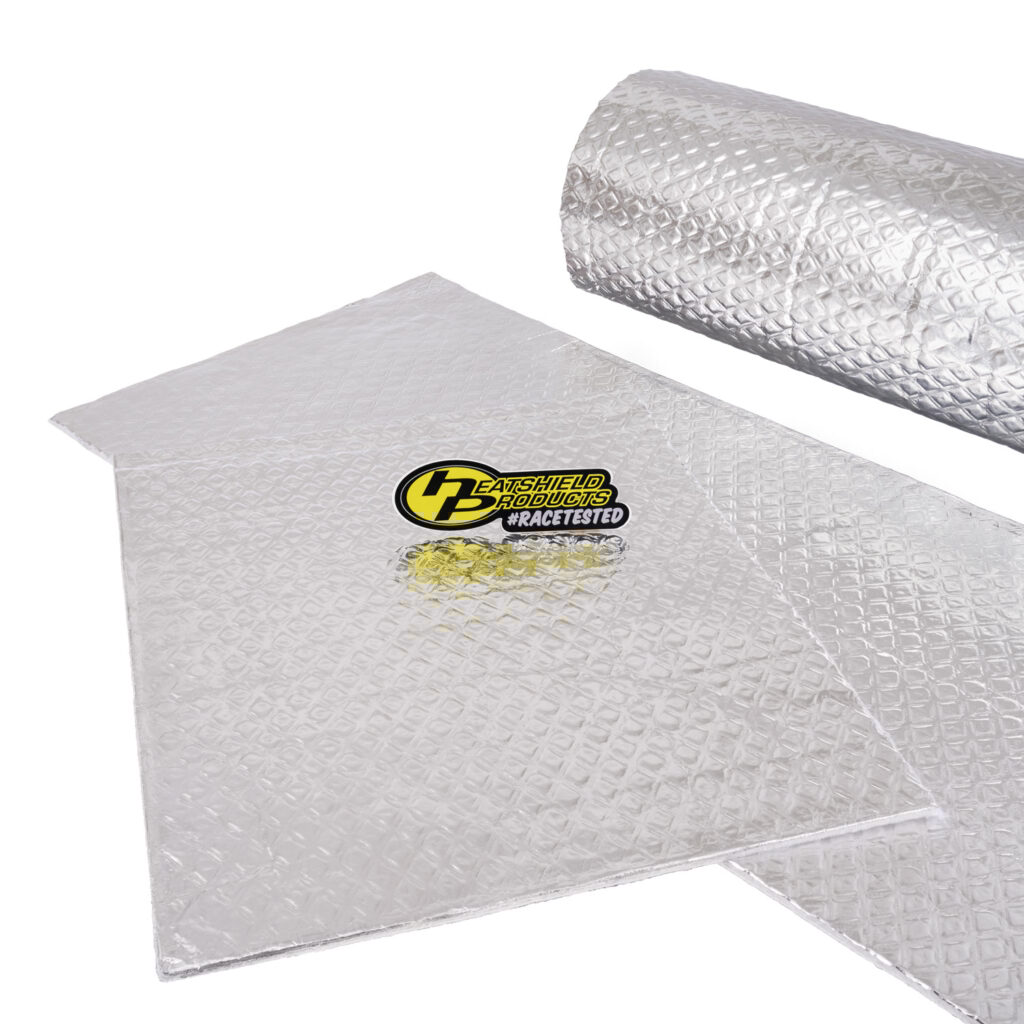Two silver, diamond-patterned heat shield insulation sheets are shown, one flat and one partially rolled up, with a HeatShield Products #Racetested logo sticker placed on top.