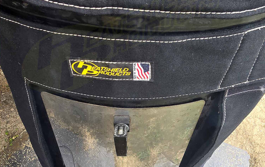 Close-up of Heatshield Products BBQoozie insulated smoker cover showing reinforced stitching and front door panel.